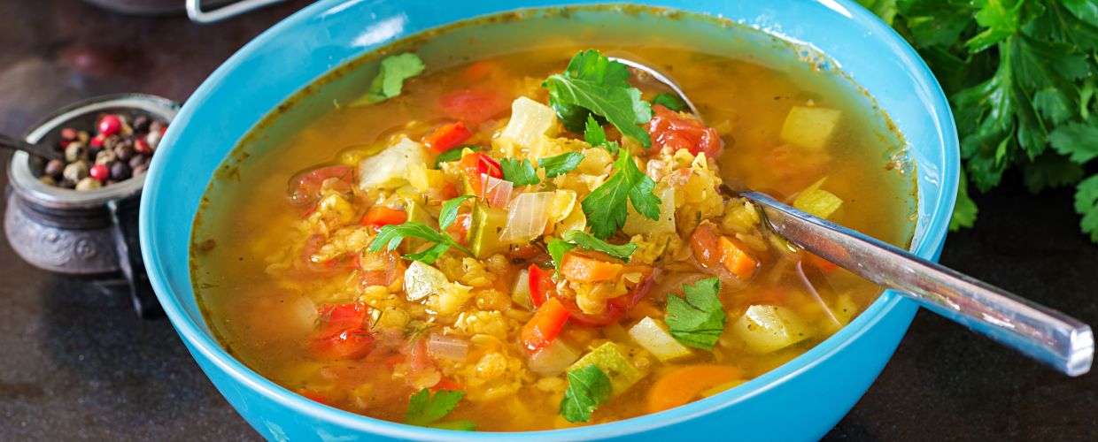 Sopa de legumes num pote azul.