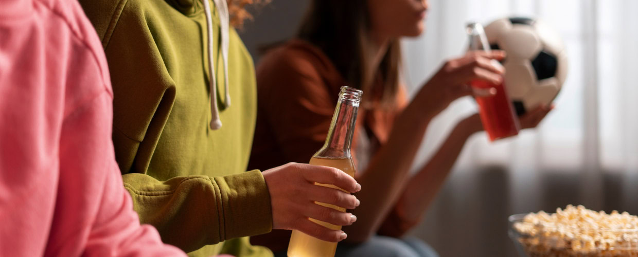 Grupo de amigos assistindo ao jogo e bebendo.