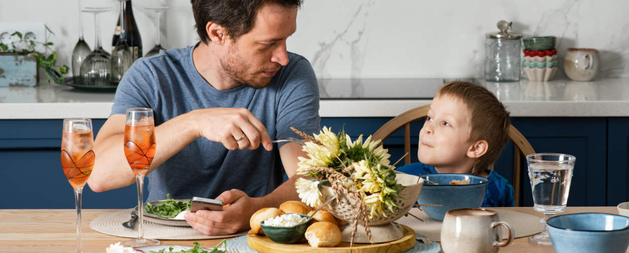 Pai e filho comendo na cozinha.