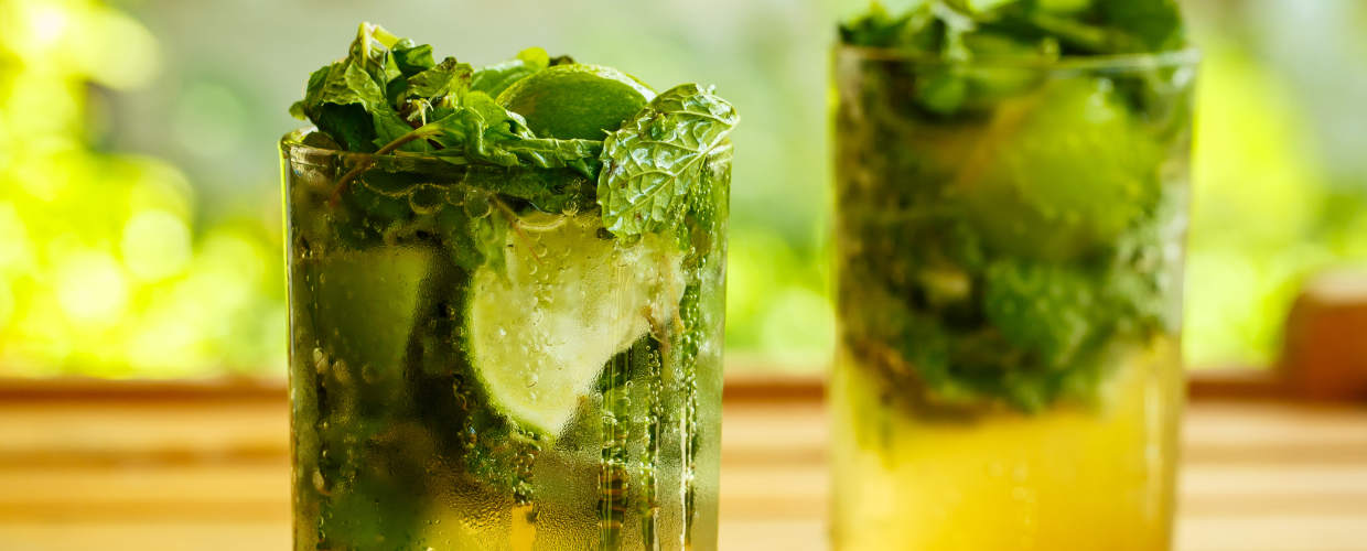 Dois copos de drinks com cerveja e limão.