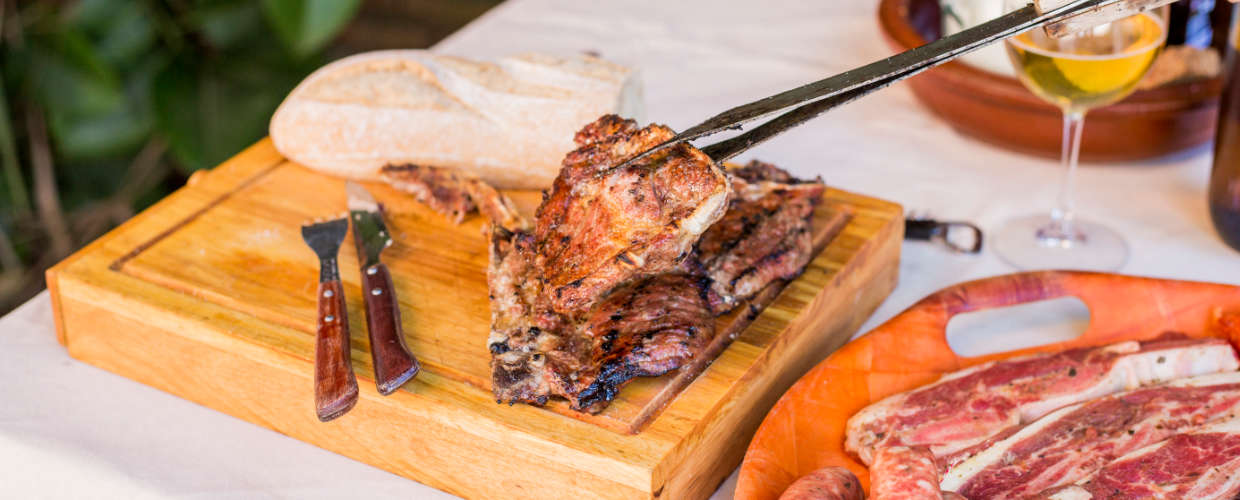 Carne sendo fatiada na tábua de madeira.