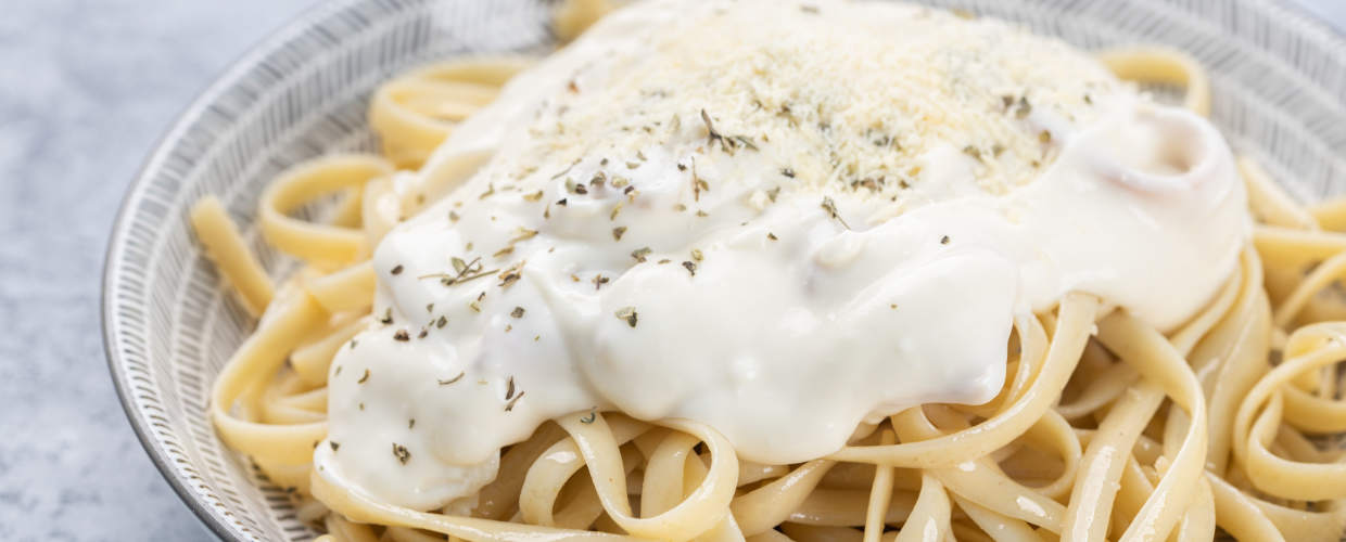 Prato com macarrão e molho branco.